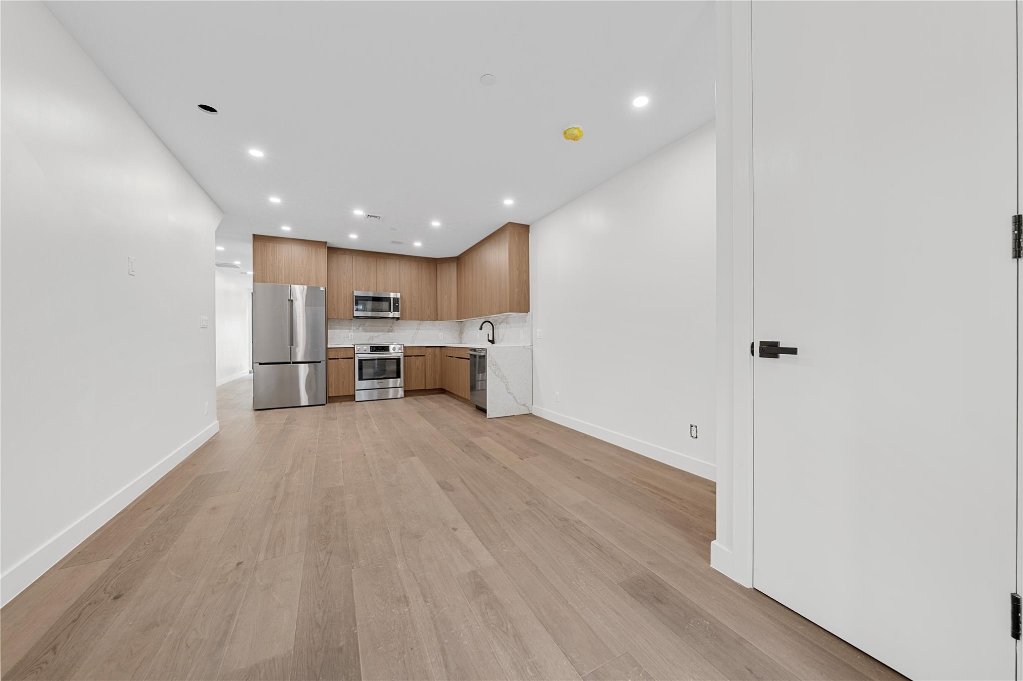 312 Fenimore Street Brooklyn, NY 11225 - Photo 6 of 37 Kitchen featuring appliances with stainless steel finishes, recessed lighting, light countertops, baseboards, and light wood-type flooring