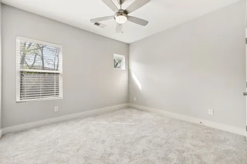 an empty room with a window and a fan