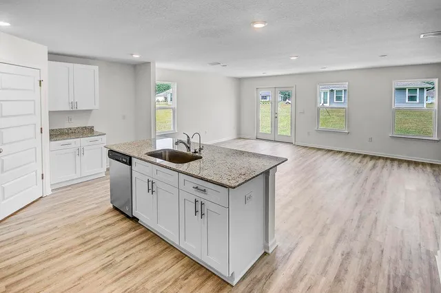 a kitchen with granite countertop a sink and a stove top oven