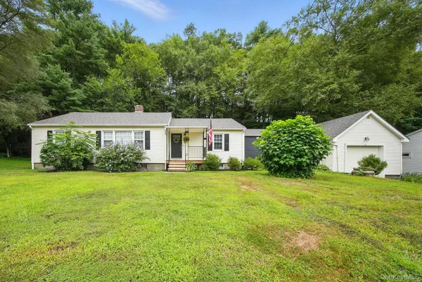 a front view of a house with a yard and trees