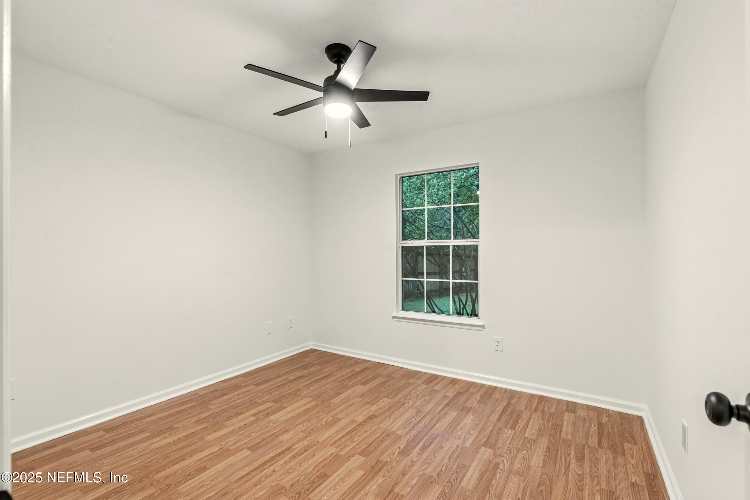 4385 Comanche Trail Boulevard St. Johns, FL 32259 - Photo 20 of 33 an empty room with wooden floor fan and windows