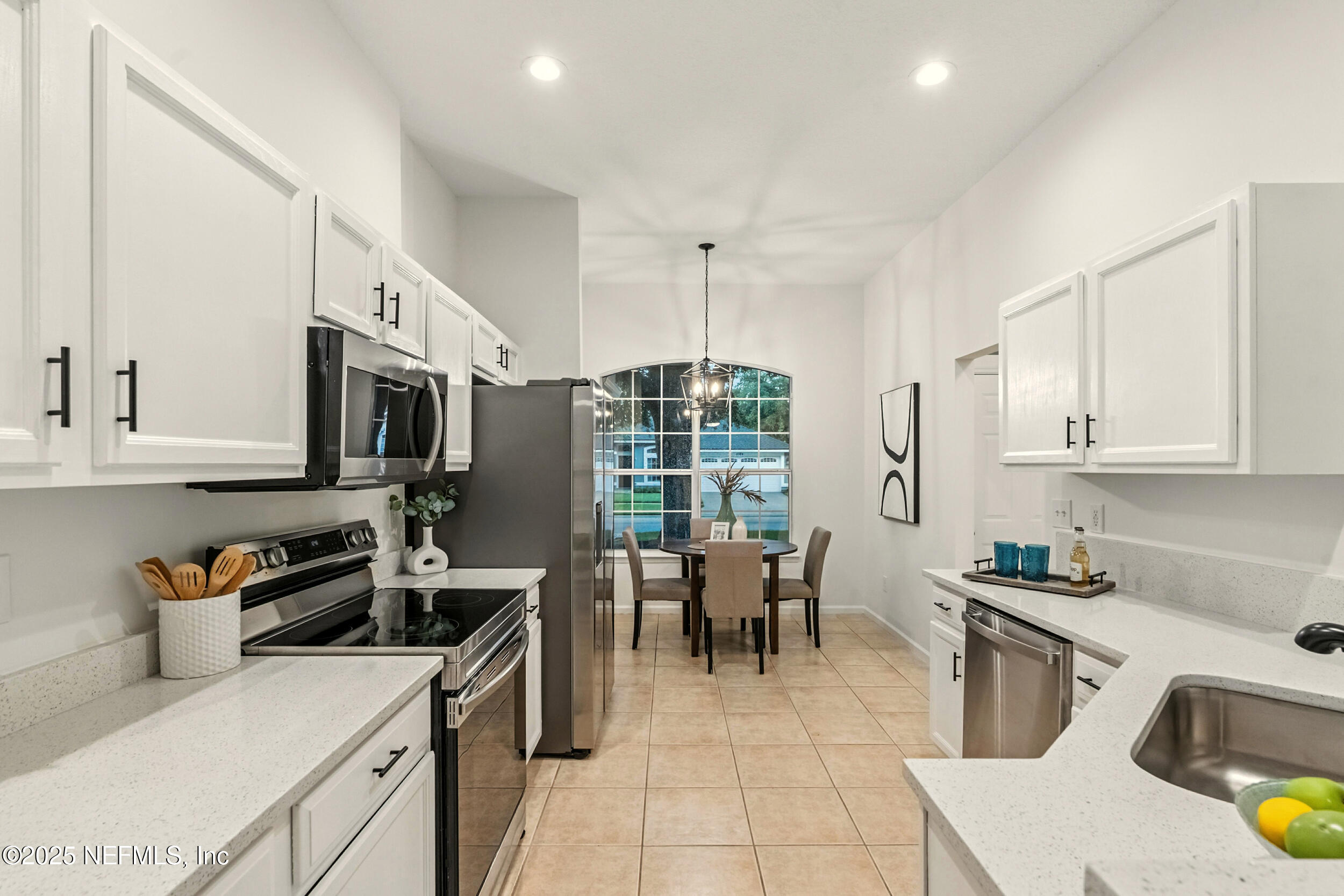 4385 Comanche Trail Boulevard St. Johns, FL 32259 - Photo 9 of 33 a kitchen with stainless steel appliances a stove a sink a microwave and a refrigerator