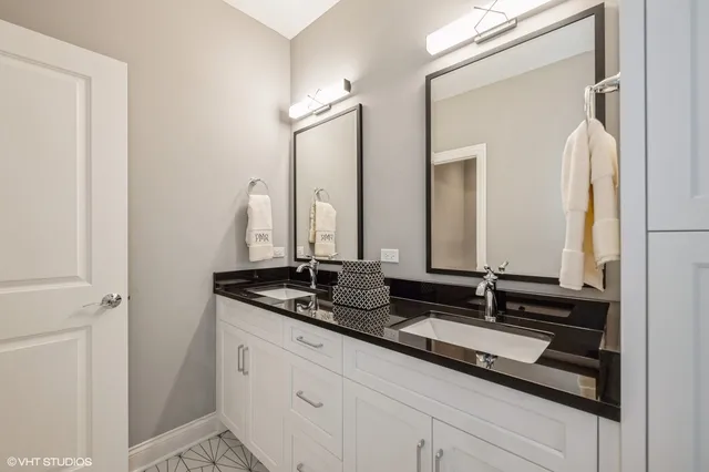 a bathroom with double sink and a mirror