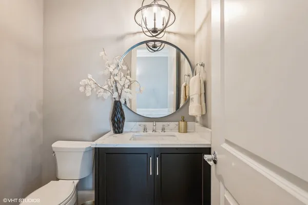 a bathroom with a sink mirror vanity and toilet