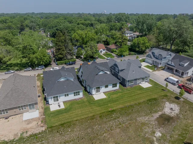 an aerial view of residential houses with outdoor space and trees