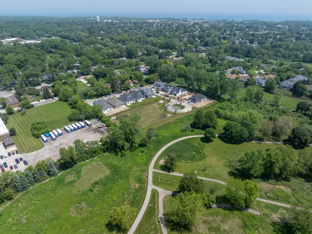 an aerial view of residential houses with outdoor space and trees