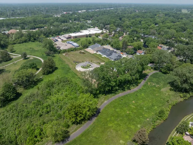 an aerial view of residential houses with outdoor space and trees