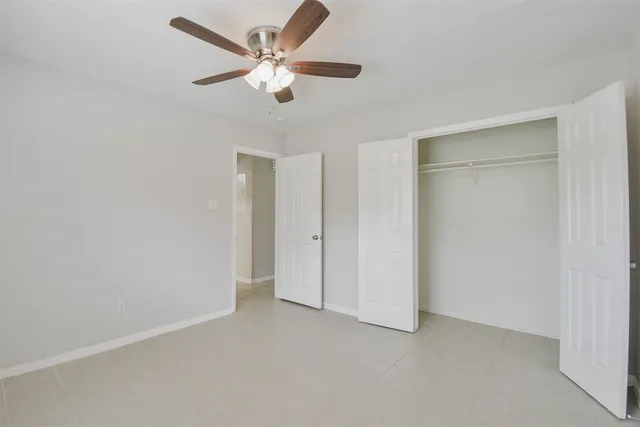 an empty room with closet and fan