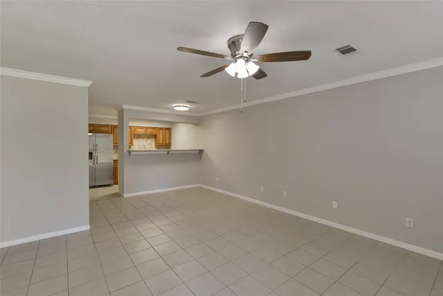 a view of a livingroom with a chandelier fan and windows