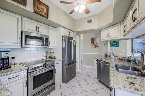 a kitchen with stainless steel appliances granite countertop a stove refrigerator and microwave
