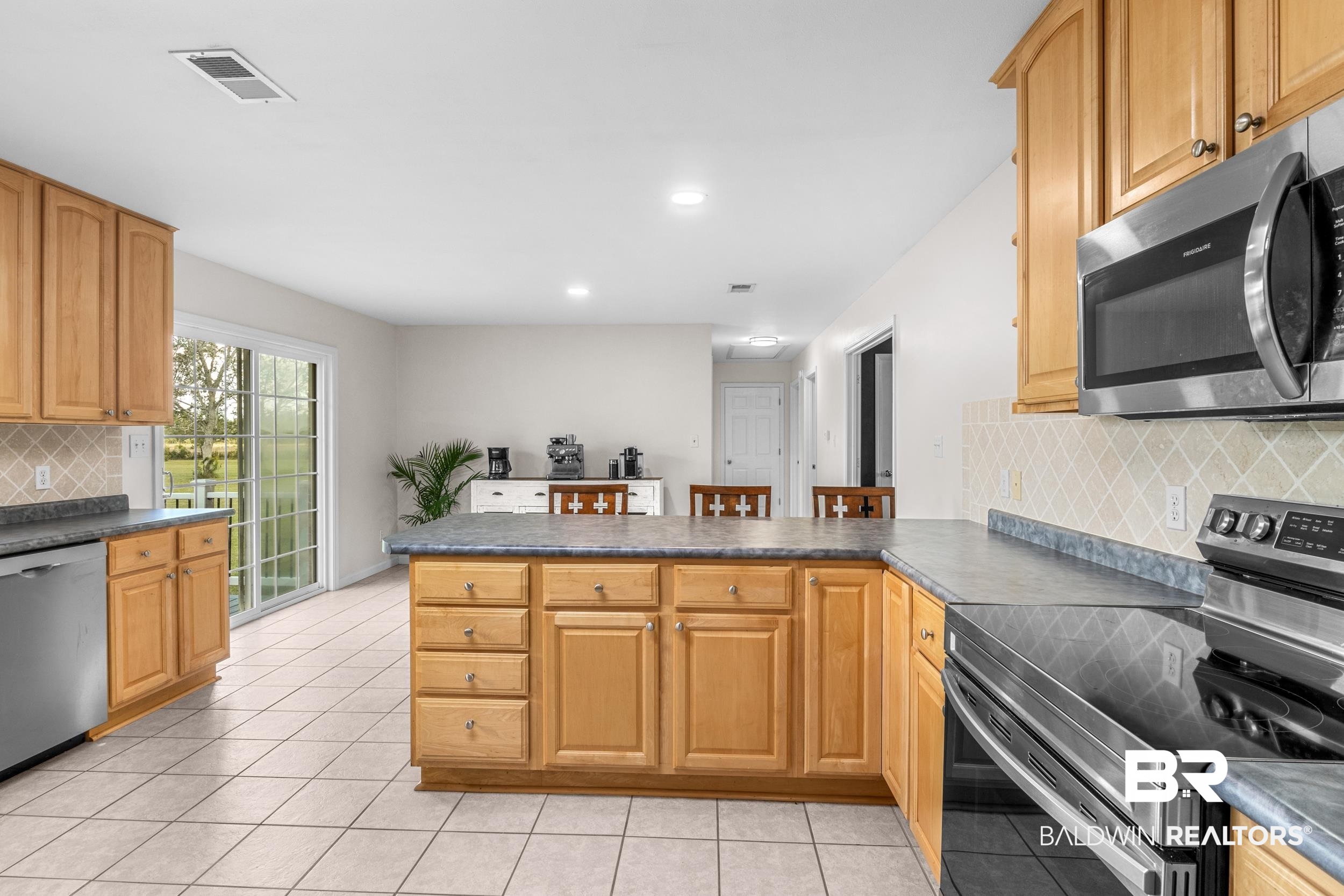 17689 Brewer Road Foley, AL 36535 - Photo 23 of 54 Kitchen with light tile patterned floors, stainless steel appliances, kitchen peninsula, and decorative backsplash