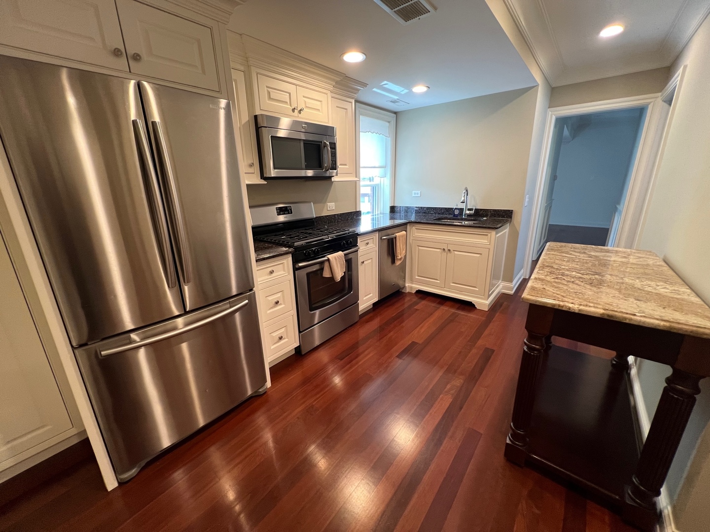 1000 Ridge Road, Unit 2 Wilmette, IL 60091 - Photo 3 of 10 a kitchen with a refrigerator stainless steel appliances wooden floor and a window