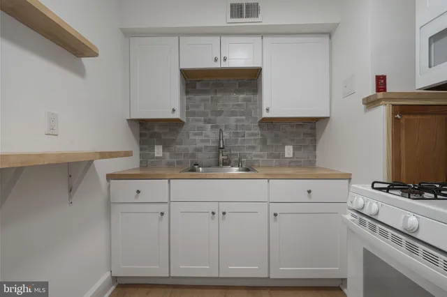a kitchen with white cabinets and appliances
