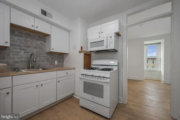 a kitchen with granite countertop white cabinets and white appliances