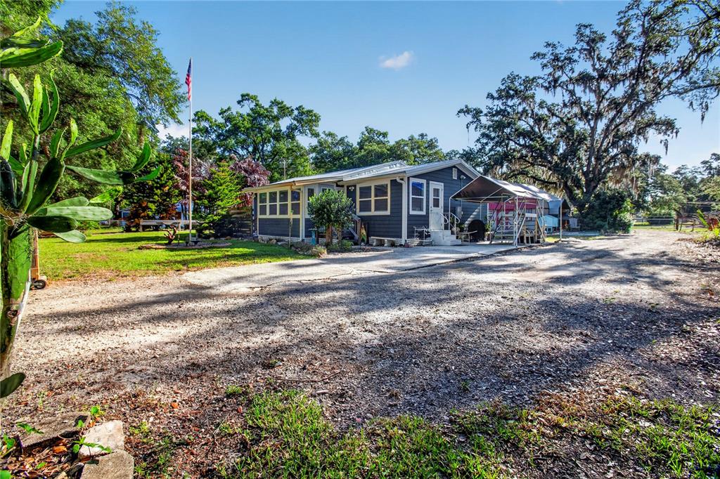 10627 McIntosh Road Thonotosassa, FL 33592 - Photo 1 of 38 a view of a house with backyard and trees