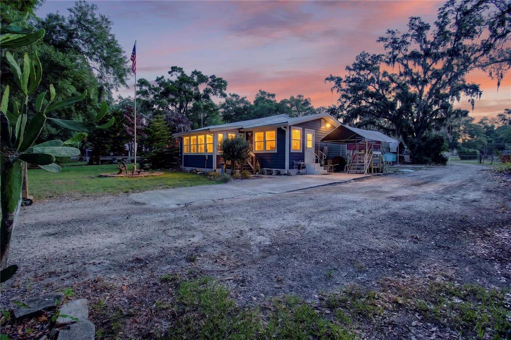 10627 McIntosh Road Thonotosassa, FL 33592 - Photo 19 of 38 a view of a house with large trees and a small yard