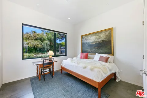 a bedroom with a bed and a large window