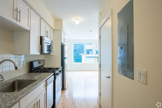 a kitchen with a refrigerator sink and cabinets