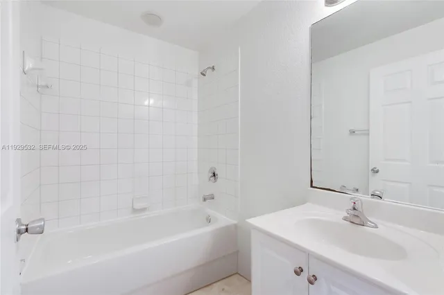 a bathroom with a bathtub sink vanity and a mirror