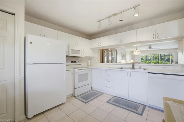 a kitchen with white cabinets and white appliances