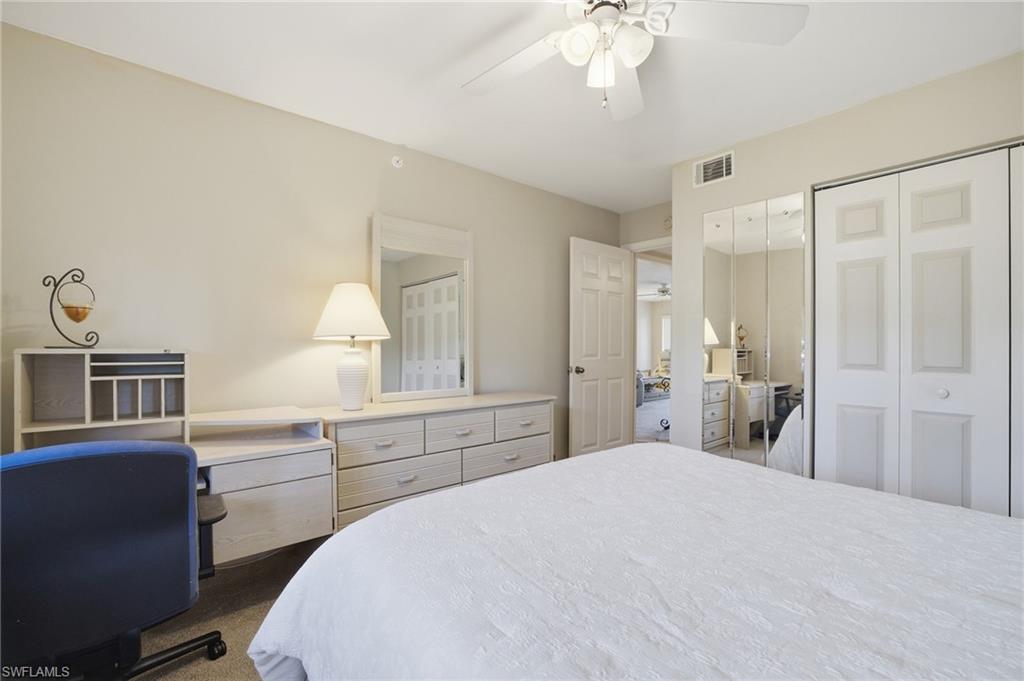 1001 Eastham Way, Unit C102 Naples, FL 34104 - Photo 16 of 41 a bedroom with a bed and a chandelier