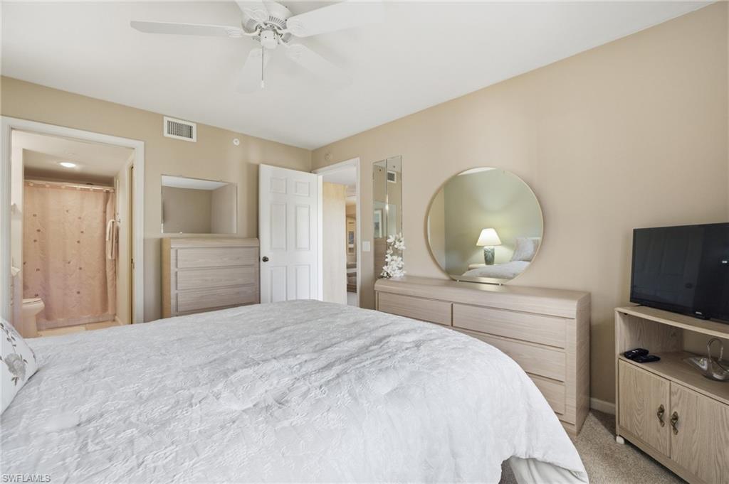 1001 Eastham Way, Unit C102 Naples, FL 34104 - Photo 22 of 41 a bedroom with a bed and a flat screen tv