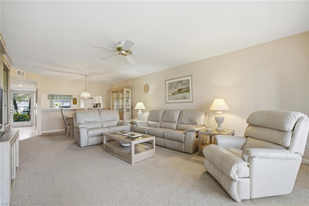 1001 Eastham Way, Unit C102 Naples, FL 34104 - Photo 6 of 41 a living room with furniture and a chandelier