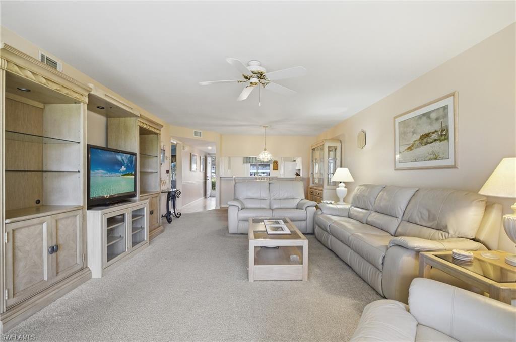1001 Eastham Way, Unit C102 Naples, FL 34104 - Photo 8 of 41 a living room with furniture a flat screen tv and kitchen view