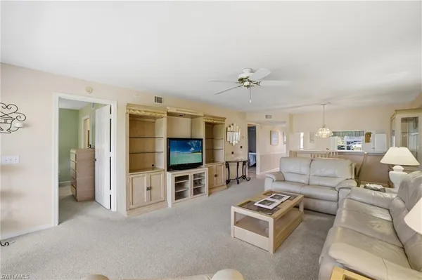 a living room with furniture a flat screen tv and kitchen view
