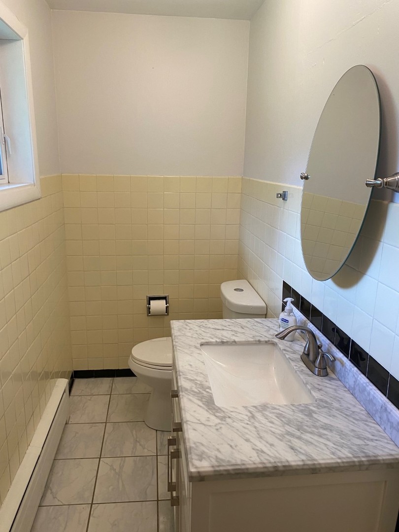 21W270 Temple Drive Itasca, IL 60143 - Photo 11 of 15 a bathroom with a sink a toilet and a mirror
