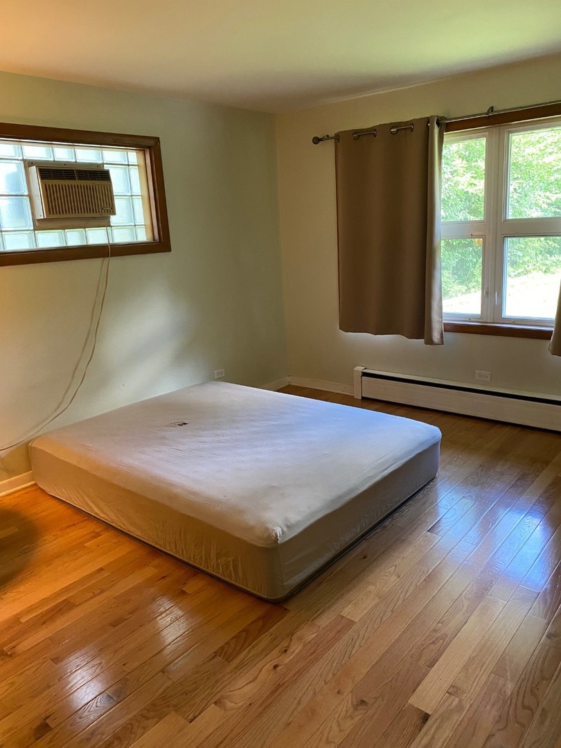 21W270 Temple Drive Itasca, IL 60143 - Photo 10 of 15 a bedroom with a bed and wooden floor