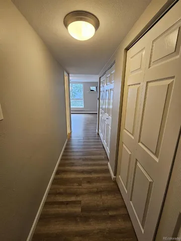 a view of a hallway with wooden floor and entryway