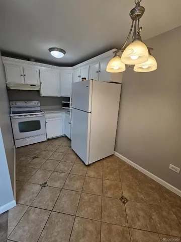 a kitchen with kitchen island granite countertop stainless steel appliances a stove a refrigerator and cabinets