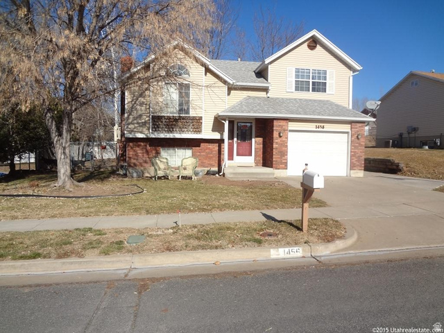 1456 West 570 North Clinton, UT 84015 - Photo 1 of 1 View of front of property with brick siding, driveway, an attached garage, a shingled roof, and a front lawn