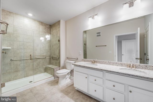 a spacious bathroom with a granite countertop sink toilet mirror and bathtub