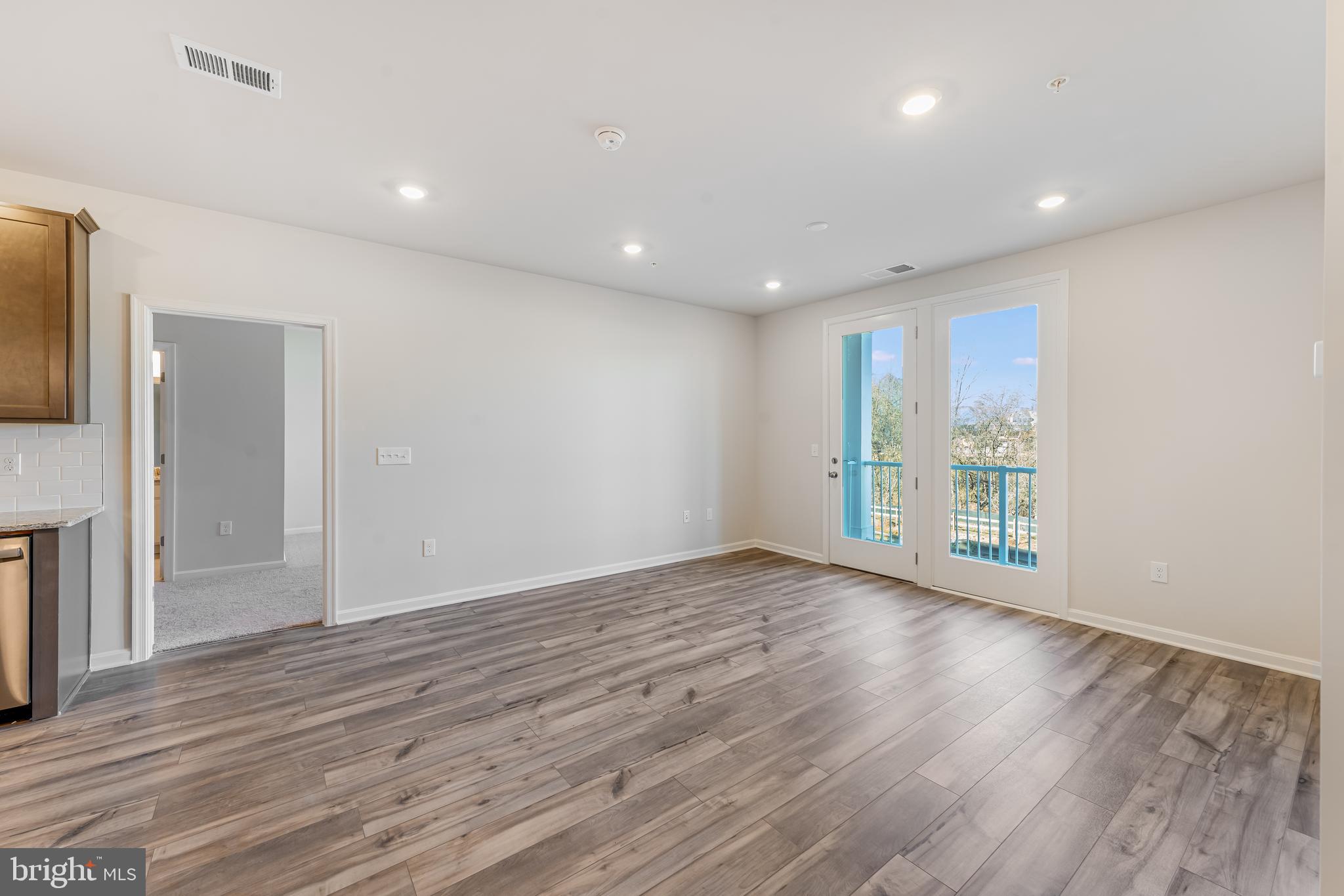 4003 Seaside Alder Road, Unit 305 VIOLET Bowie, MD 20720 - Photo 10 of 18 a view of an empty room with wooden floor and a window