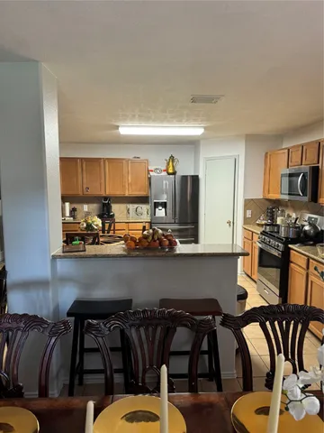 a kitchen with a table chairs stove and cabinets