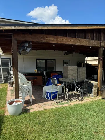 a view of a patio with table and chairs under an umbrella