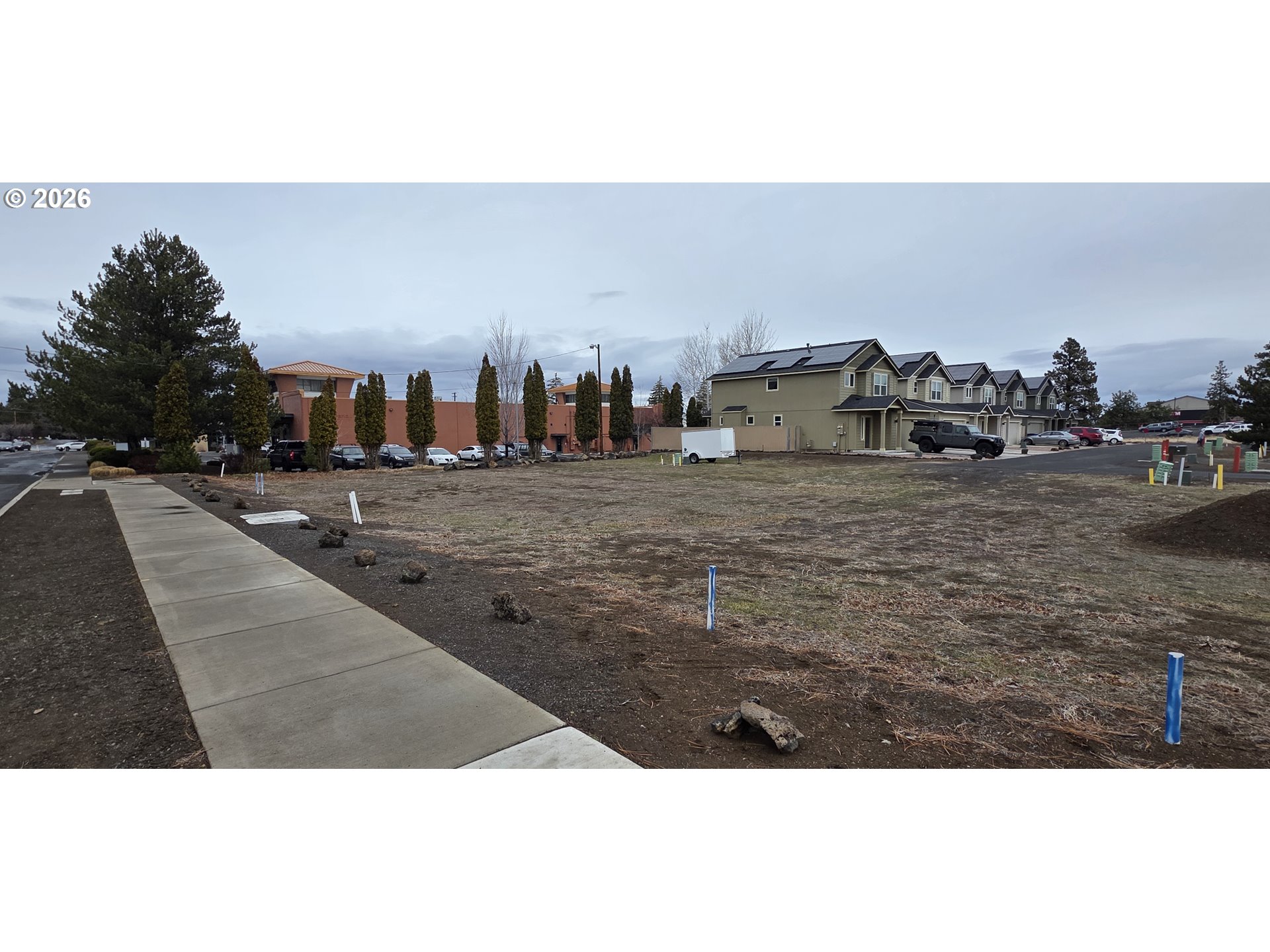 62062 Dean Swift Road Bend, OR 97701 - Photo 4 of 6 a view of a dry yard with trees and cars parked