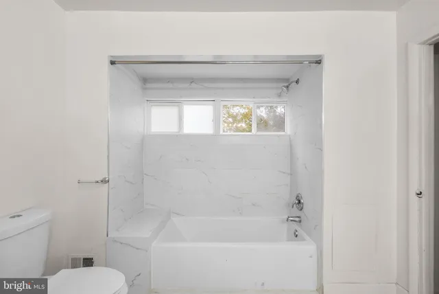 a bathroom with a toilet and bathtub