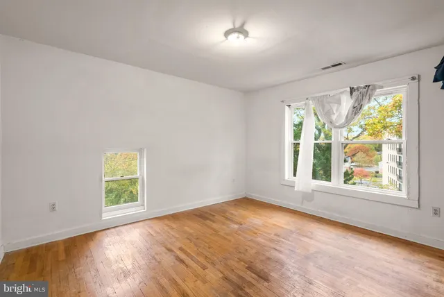 a view of a room with wooden floor and white walls