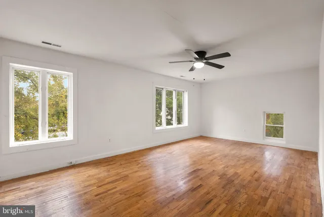 a view of an empty room with a ceiling fan