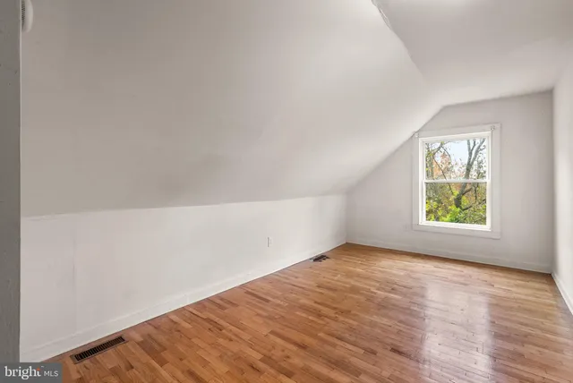 a view of empty room with wooden floor
