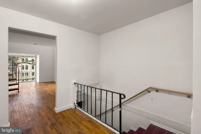 a view of a hallway with wooden floor and staircase