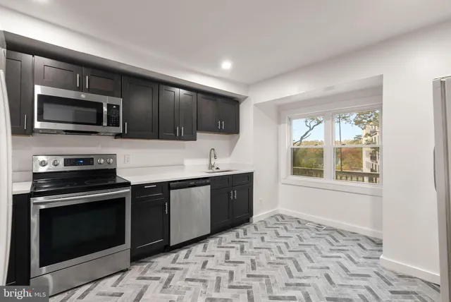 a kitchen with a stove sink and microwave