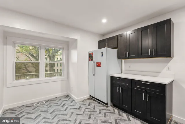 a kitchen with a refrigerator sink and cabinets