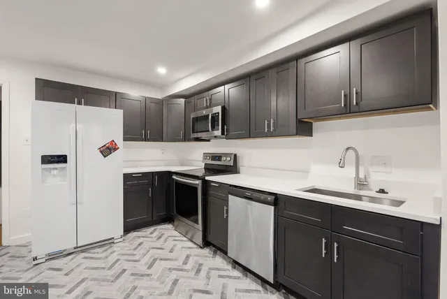 a kitchen with stainless steel appliances granite countertop a refrigerator sink and cabinets