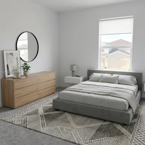 a bedroom with a bed mirror and a window