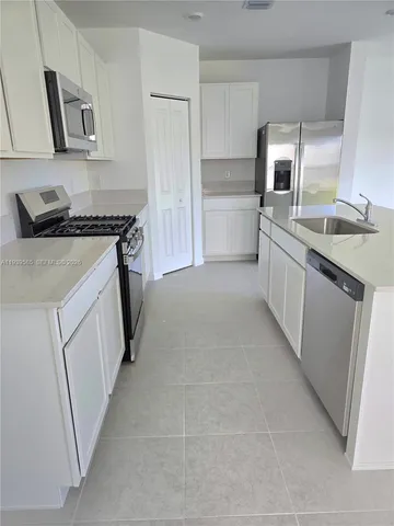 a kitchen with granite countertop a sink stove and refrigerator
