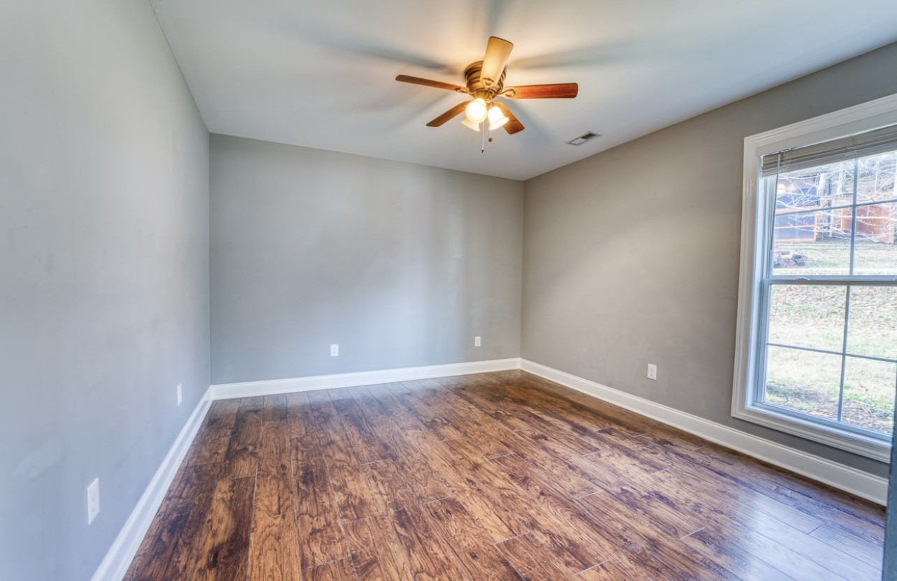 807 Clear Creek Road Pulaski, TN 38478 - Photo 11 of 17 an empty room with wooden floor and windows